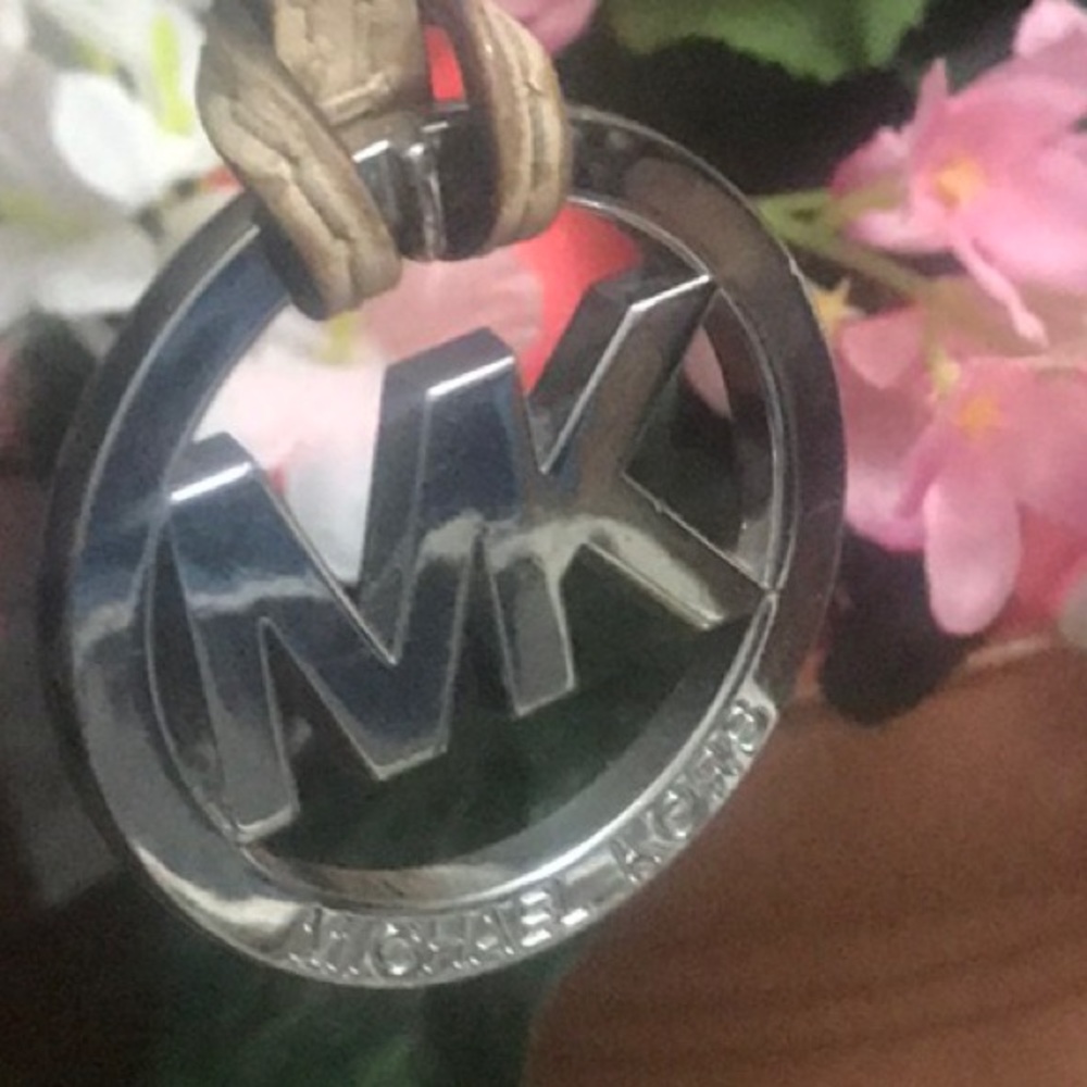 Michael Kors silver tone bag charm with cream leather cord